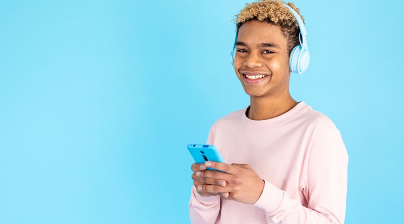 Jongen met koptelefoon en mobiele telefoon