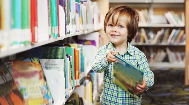 foto van kind uit de onderbouw in bibliotheek met boek